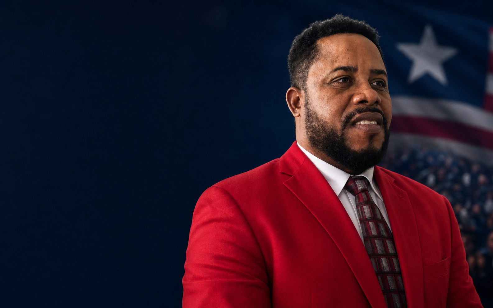 Alvin Jones wearing his red campaign suit in front of the Liberian flag